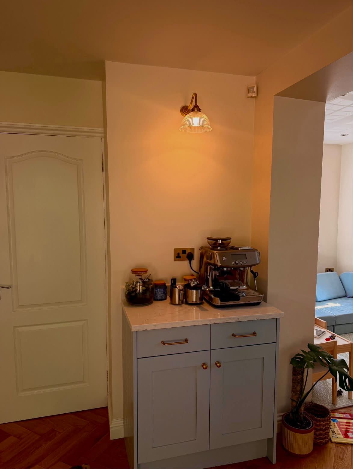 Brass ribbed glass wall sconce and socket installation in residential hallway