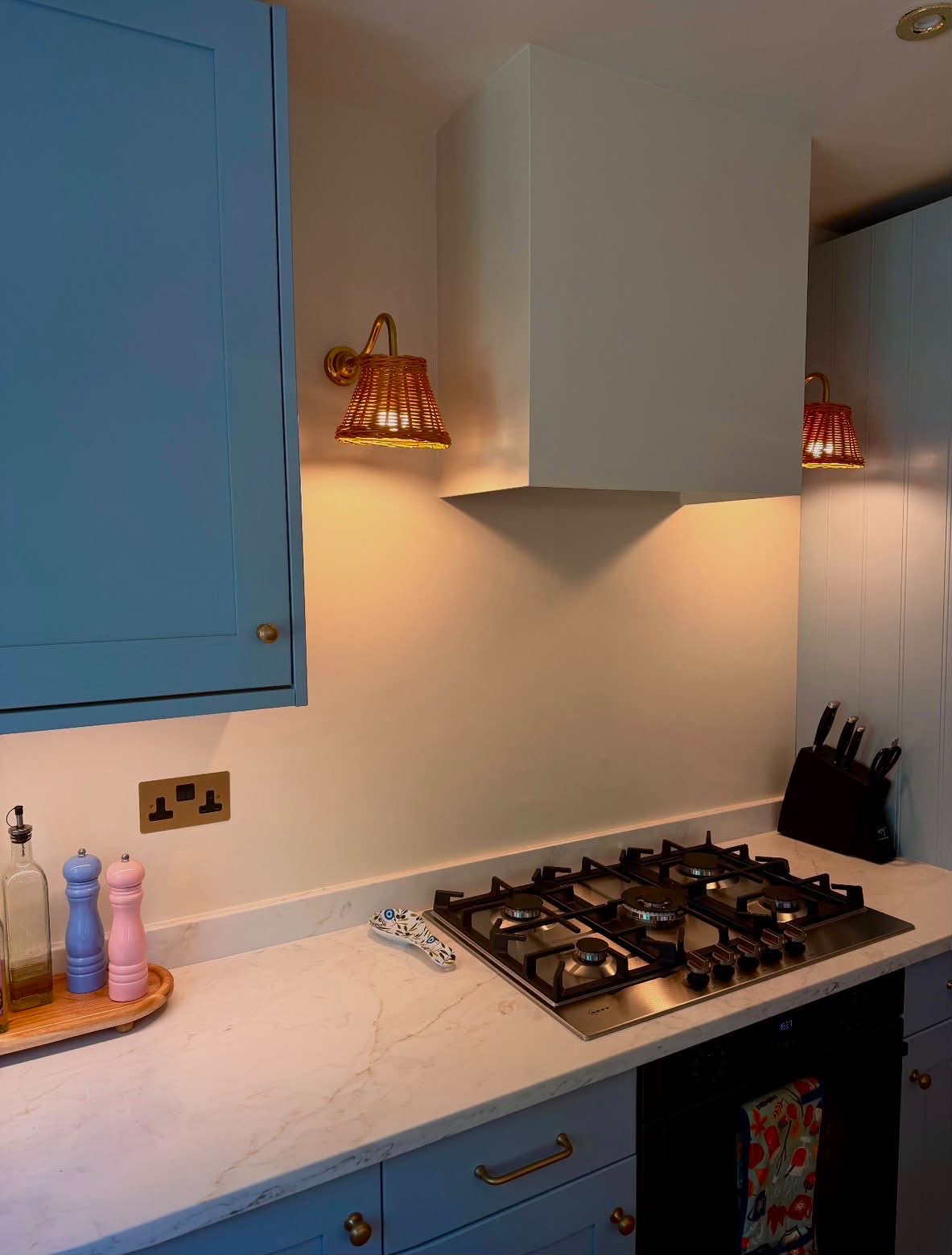 Residential kitchen wicker wall sconce lighting and brass double socket installation